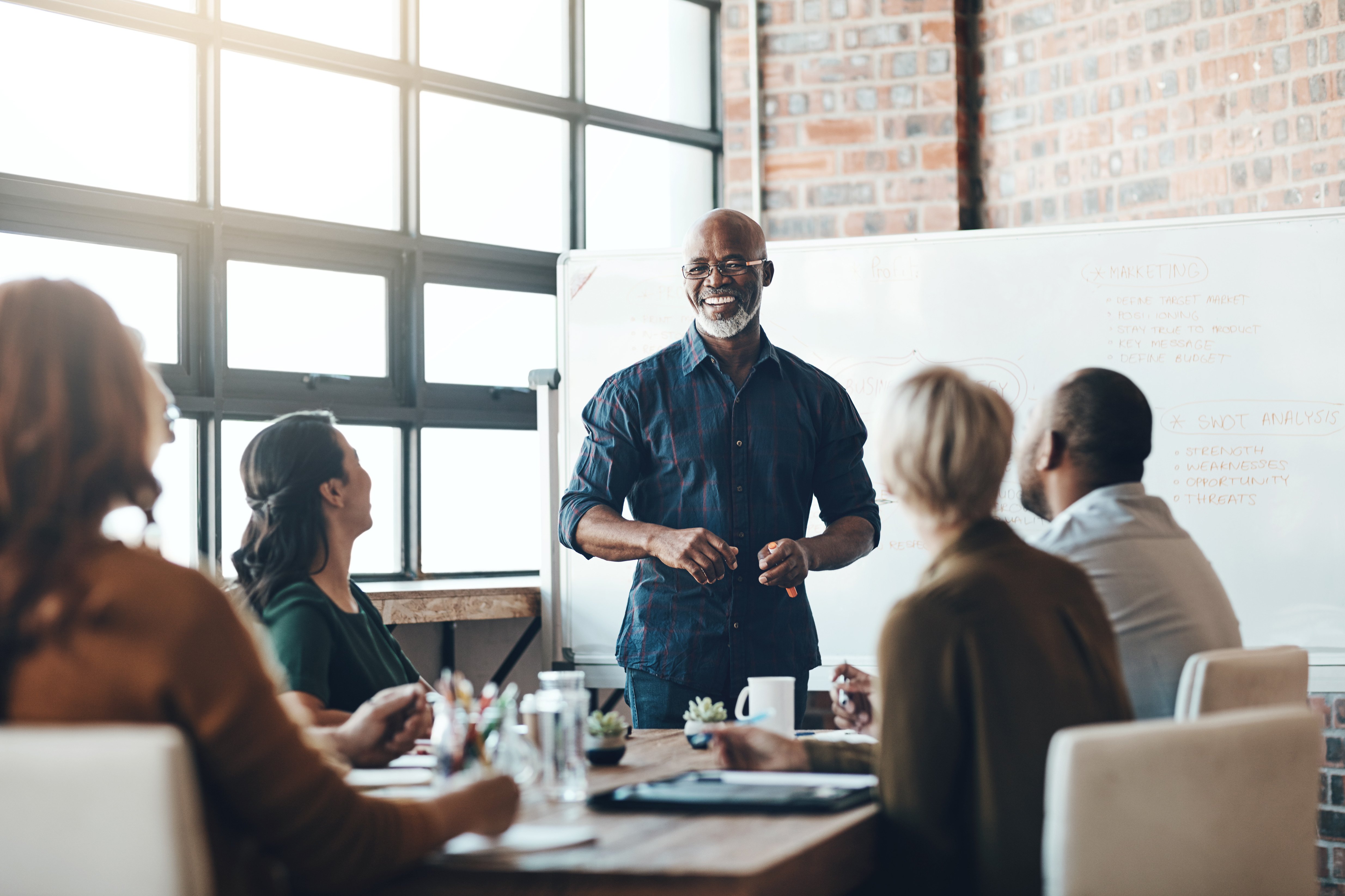 Man speaking to a group of coworkers at an office